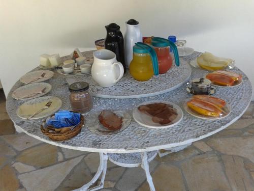 a white table with plates of food on it at Acomodação Penedo in Penedo