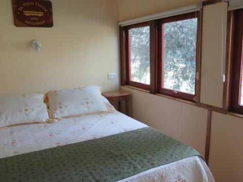 una camera da letto con un letto e due finestre di El Viejo Vagon 1908 a San Rafael