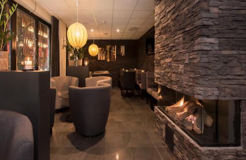 a dining room with a fireplace in a restaurant at Best Western Hotel City Gavle in Gävle