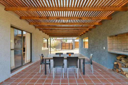 a patio with a table and chairs under a wooden ceiling at Casas Acrux in Nono