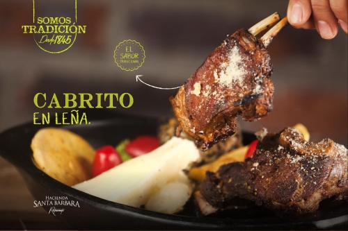 サン・ヒルにあるHotel Hacienda Santa Barbaraのフライパンに肉と果物を入れている人