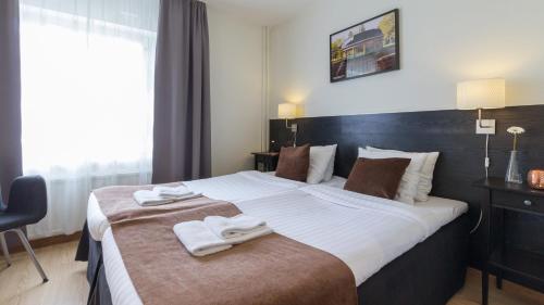 a bedroom with a large bed with towels on it at Best Western Hotel City Gavle in Gävle