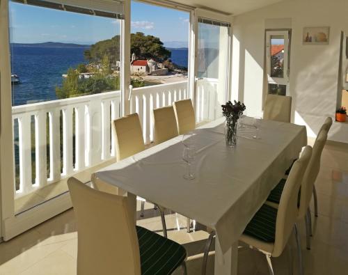 uma sala de jantar branca com uma mesa e cadeiras brancas em Apartment Ana Marija Savar em Savar