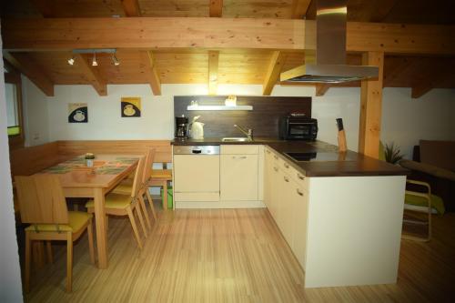 a kitchen with a wooden table and a kitchen with a dining room at Apart Dominika in Ried im Oberinntal