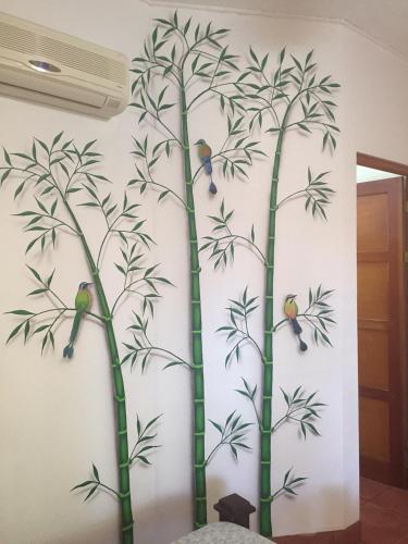 a mural of bamboo trees with birds on a wall at Hotel Tropical Sands Dominical in Dominical