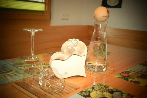 a wooden table with a heart and two glass vases at Apart Dominika in Ried im Oberinntal