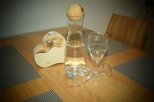 a vase and two glasses on a wooden table at Apart Dominika in Ried im Oberinntal