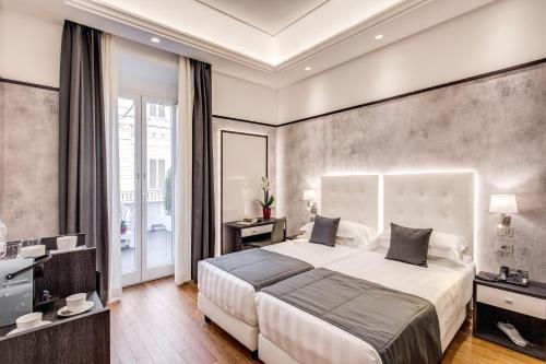 a bedroom with a large bed and a television at The Liberty Boutique Hotel in Rome