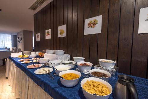une longue table avec des bols de nourriture dans l'établissement Aparthotel Aspen, à Bansko