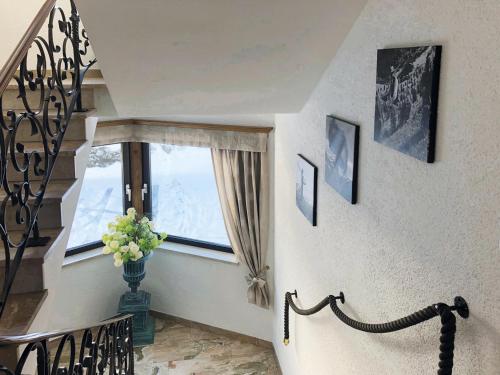 a staircase with a window and a vase of flowers at Ferienwohnungen Meusburger in Tannheim