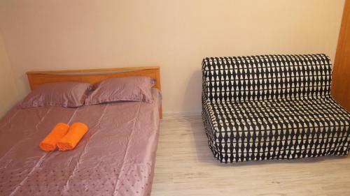 モスクワにあるApartments Presnenskiy Valのベッド1台(オレンジ色のスリッパ2枚付)