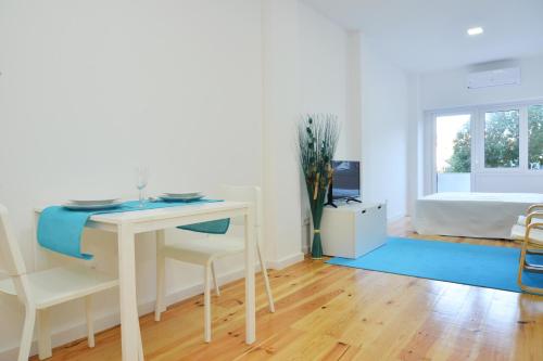 a white room with a desk and a bed at Real Home in Sacavém