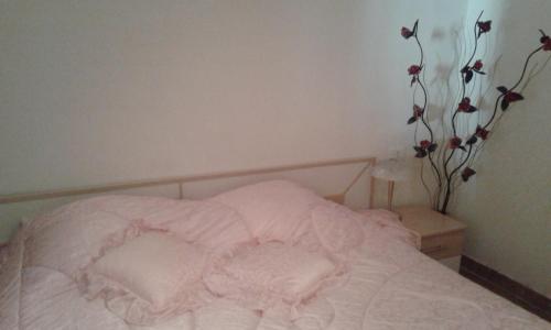 マリーナ・ディ・アンドーラにあるAppartamento in magnifica zona residenzialeのベッドルーム1室(花の壁に白いベッド1台付)