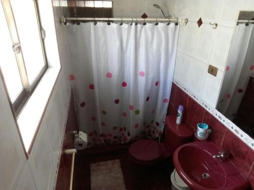 baño con aseo rojo y cortina de ducha en Casa La Serena, en La Serena