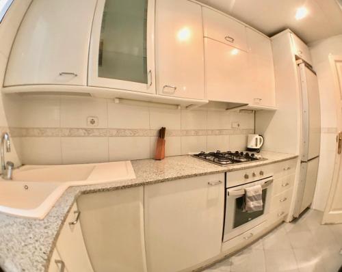 バルセロナにあるプラザ エスパーニャ セントラル アパートメントのキッチン(白いキャビネット、コンロ付)