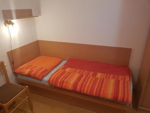a bed in a room next to a lamp and a chair at RATOMAS, s.r.o. in Kostelec na Hané