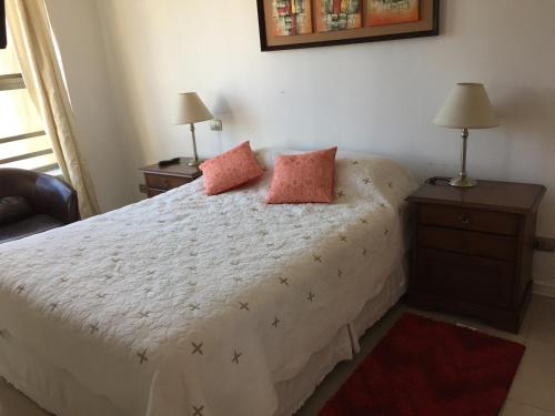 a bedroom with a bed with two pillows on it at Departamento Suke in Viña del Mar
