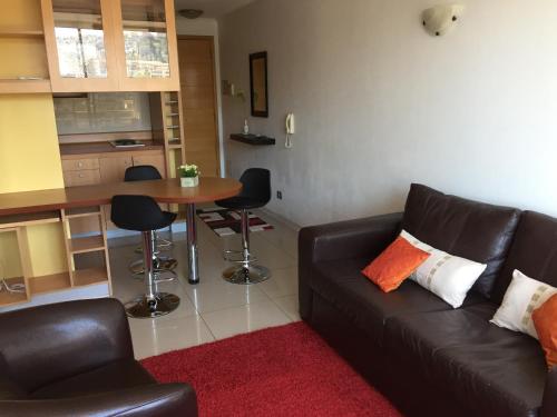 a living room with a couch and a table with chairs at Departamento Suke in Viña del Mar