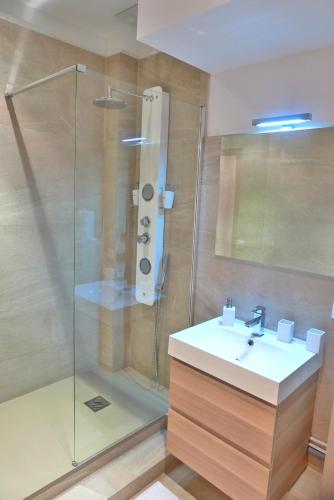 une salle de bain avec une douche en verre et un lavabo dans l'établissement Stylish two-bedroom apartment -StayInAntibes - 5 Soleau, à Antibes