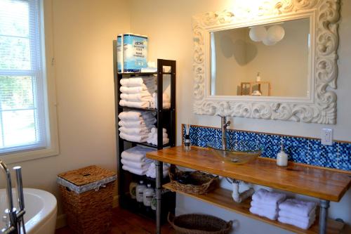 a bathroom with a sink and a mirror and towels at La Maison jaune de Chute-Saint-Philippe in Lac-Saint-Paul