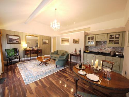 a living room with a table and a couch at The Carriage Houses at Beechpark House in Bunratty