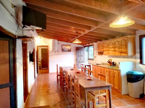 a kitchen with a wooden table and chairs in it at Casa La Montaña in El Cedro