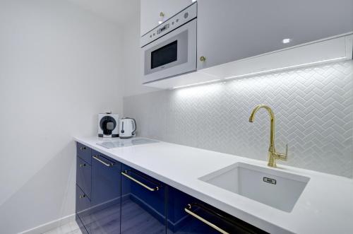 a kitchen with a sink and a microwave at Modern Place Apartament przy plaży in Gdynia