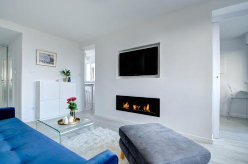 a living room with a blue couch and a fireplace at Modern Place Apartament przy plaży by PIROKO in Gdynia