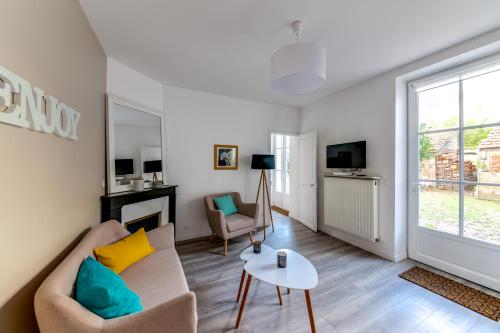 un salon avec un canapé et une table dans l'établissement Fontainebleau Sweet Home Garden, à Fontainebleau