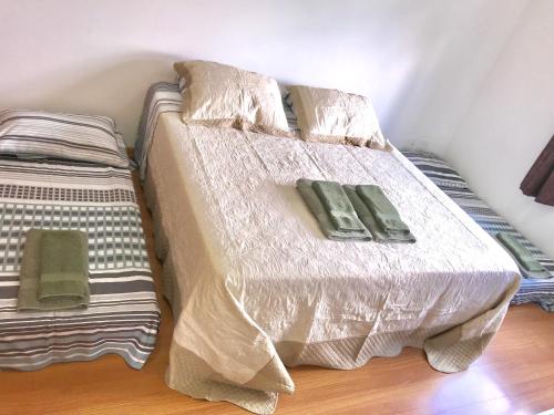 a bed with two green pillows on top of it at Apartamento no Centro de Gramado in Gramado