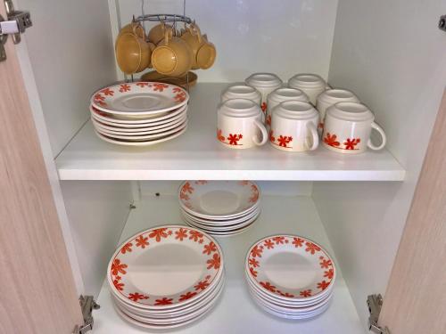 a shelf full of plates and cups and dishes at Apartamento no Centro de Gramado in Gramado