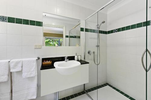 a white bathroom with a sink and a shower at Azura Beach House B&B in Port Macquarie