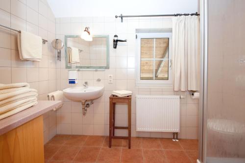 a white bathroom with a sink and a mirror at Stadler Hof in Großgundertshausen