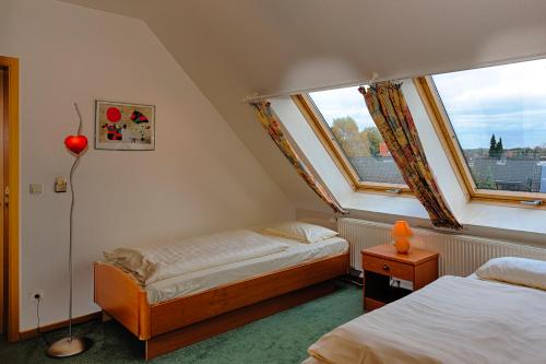 a small bedroom with two beds and a window at Hotel Ideal in Lübeck