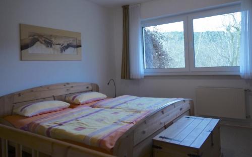 a bedroom with a wooden bed and a window at Dümpelhof Ferienwohnungen in Olsberg