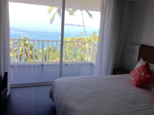 a bedroom with a bed and a view of the ocean at Vista Mare Spectacular Ocean View Top Floor 1-Bedroom Condo, Samana in Santa Bárbara de Samaná