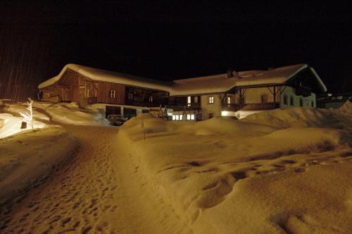 a house is covered in snow at night at Alfaierhof-Bergheimat in Gschnitz