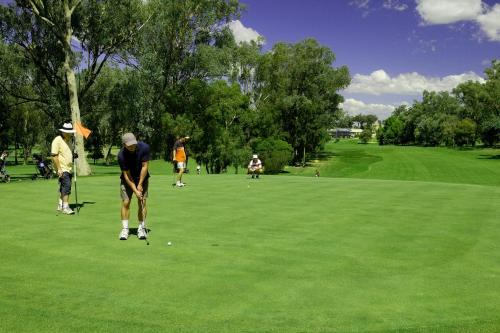 a group of people playing golf on a golf course at Commercial Golf Resort in Albury