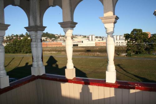 a view from the porch of a building with columns at Arthouse Hostel in Launceston
