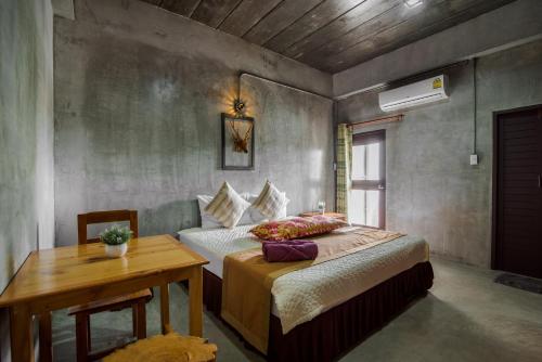 a bedroom with a bed and a table in it at Lovely Guesthouse 94 in Hua Hin