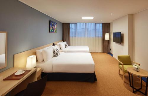 a hotel room with two beds and a desk at Days Hotel & Suites by Wyndham Incheon Airport in Incheon