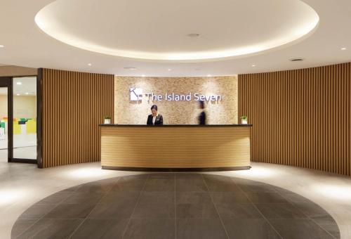 a man standing at a counter in a lobby at Days Hotel & Suites by Wyndham Incheon Airport in Incheon