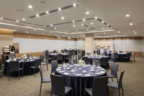 a ballroom with tables and chairs and a room filled with at Days Hotel & Suites by Wyndham Incheon Airport in Incheon