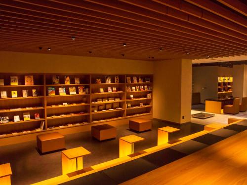 a library with benches and shelves with books at UAN kanazawa in Kanazawa