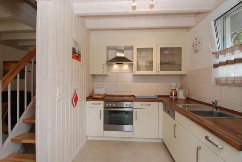 a kitchen with white cabinets and a sink at Strandpark Baabe Haus 224 in Baabe