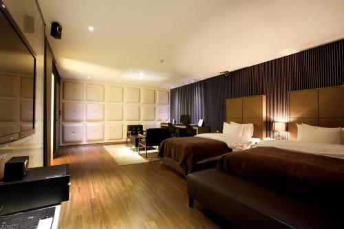 Habitación de hotel con 2 camas y escritorio en Uijeongbu Latree Hotel en Uijeongbu
