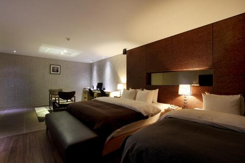 Uijeongbu Latree Hotel tesisinde bir odada yatak veya yataklar