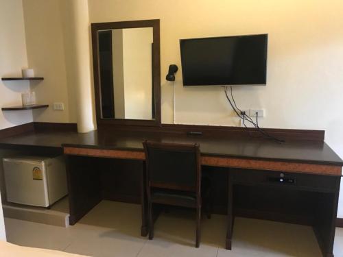 a desk with a television and a mirror in a room at Room Place in Chumphon