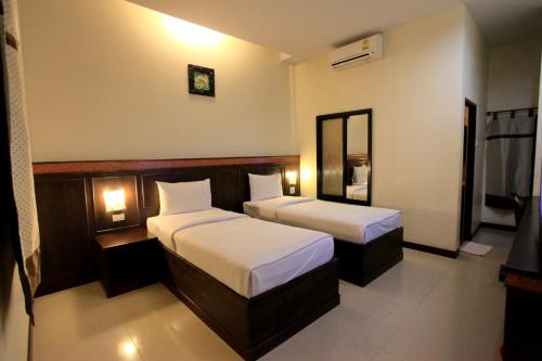a hotel room with two beds and a mirror at Room Place in Chumphon