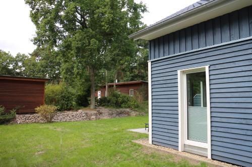 a blue house with a door and a yard at Strandhus Baabe Haus 3 in Baabe